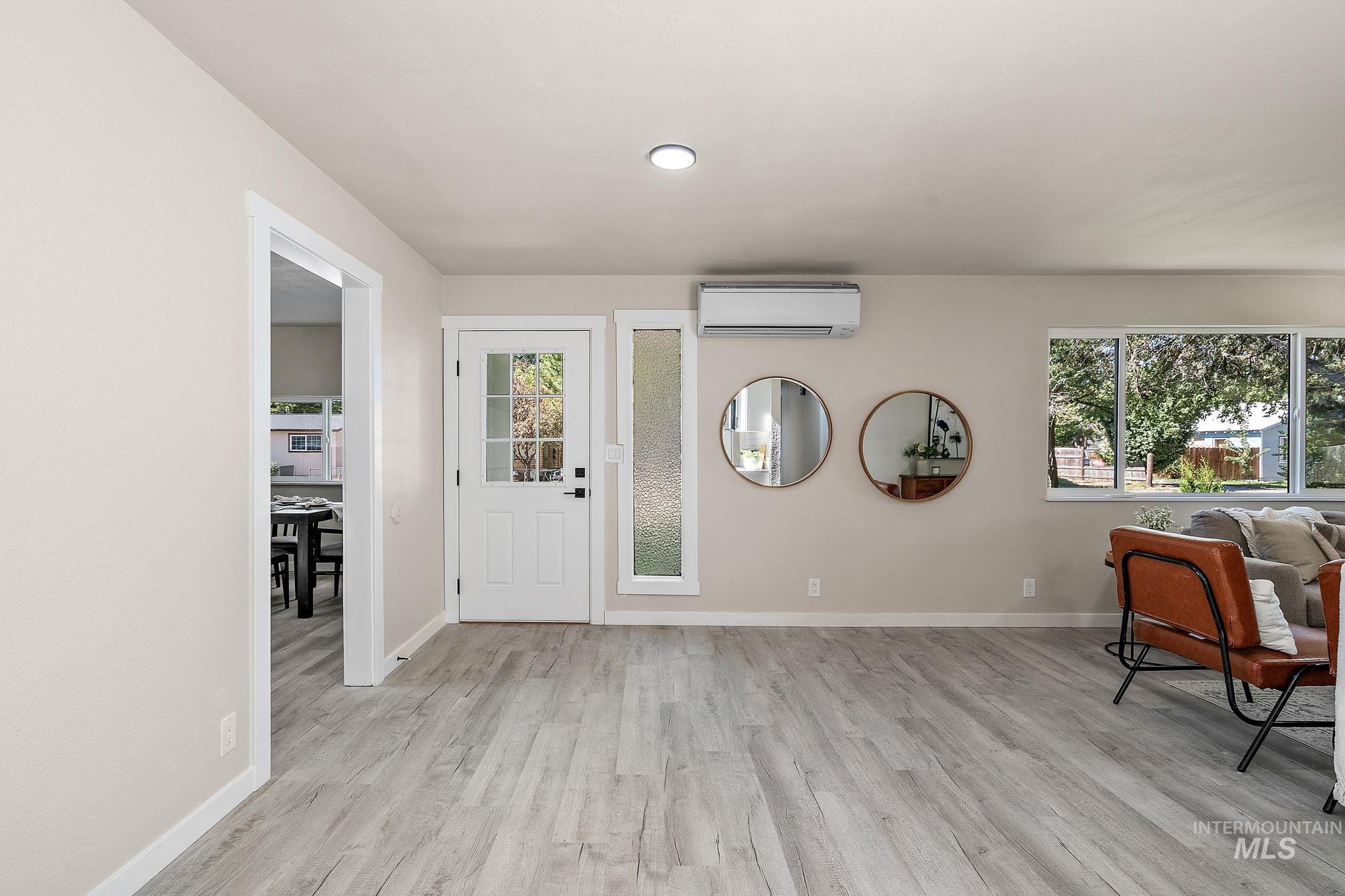 Foyer entrance with light wood-type flooring, healthy amount of natural light, a wall mounted AC, and recessed lighting