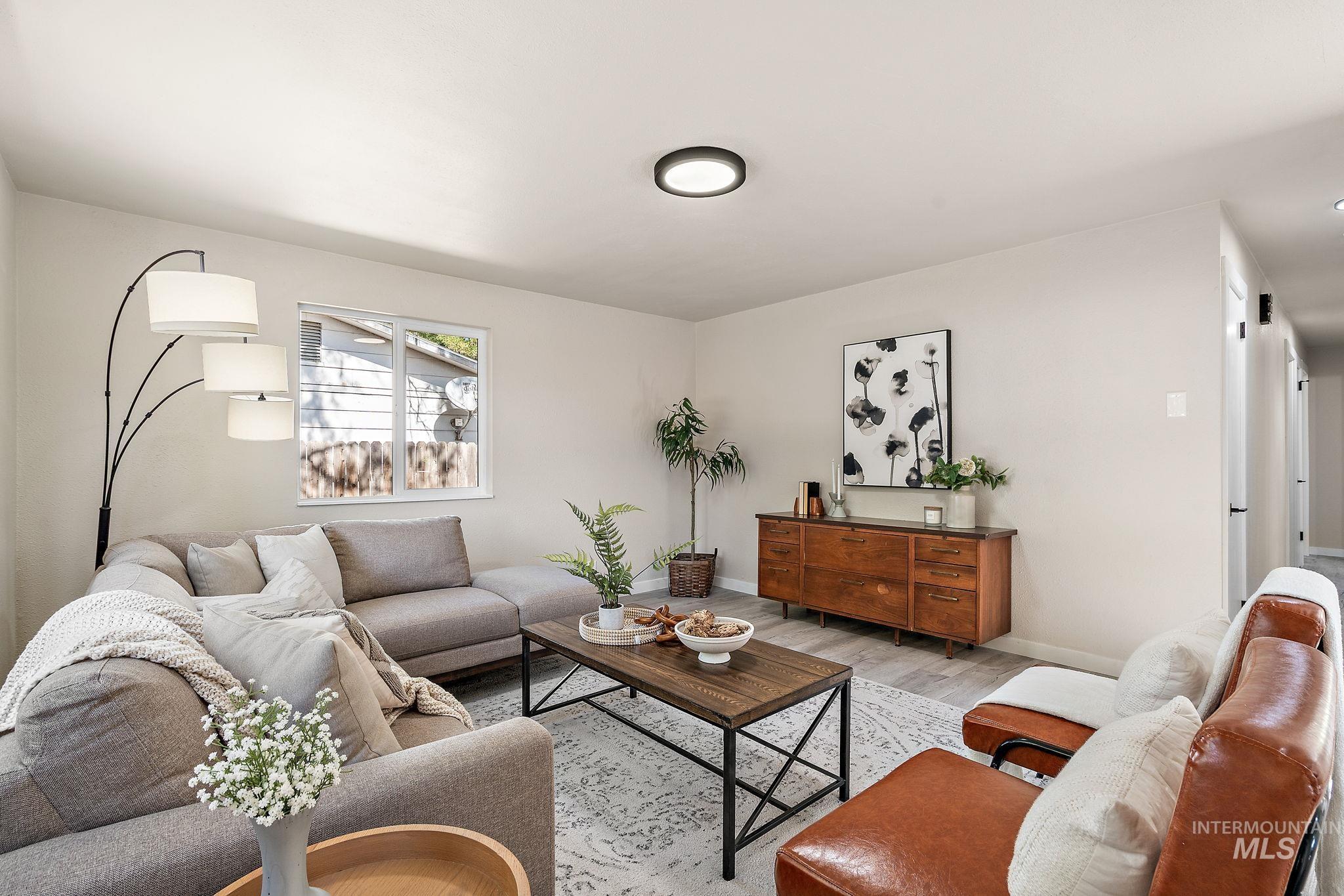 Living room with light wood-type flooring and baseboards