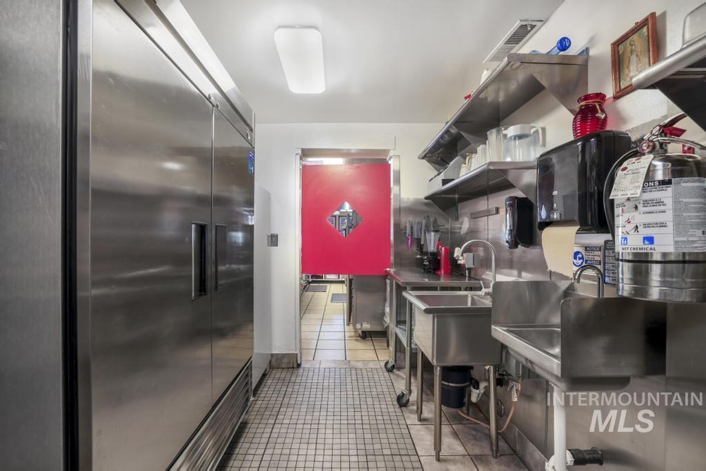 Kitchen featuring open shelves, light tile patterned floors, and built in fridge
