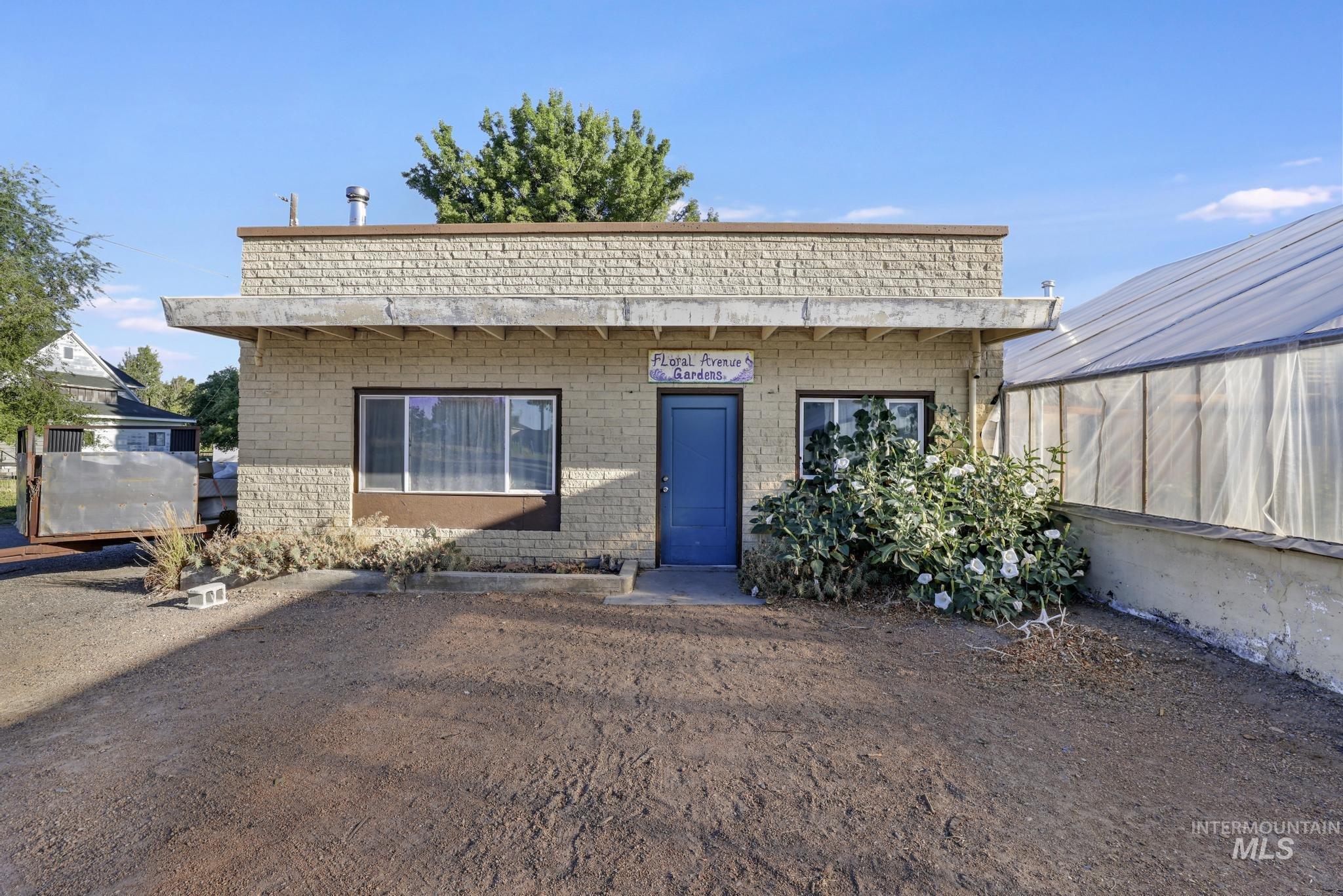View of front of property with an exterior structure, an outdoor structure, and brick siding