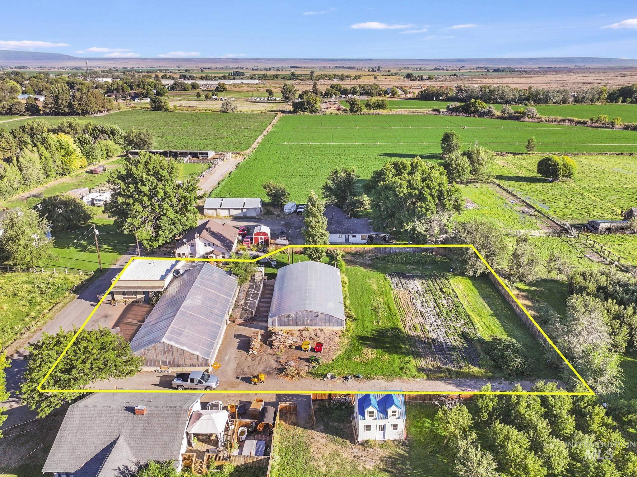View of rural area with property parcel outlined and rows of crops