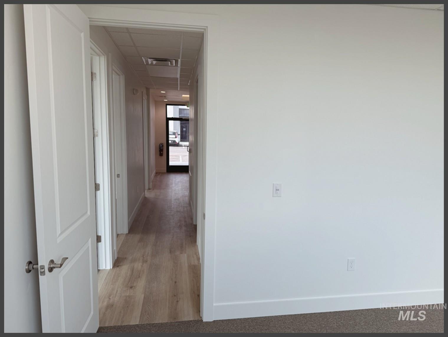 Hall featuring a paneled ceiling and light wood finished floors
