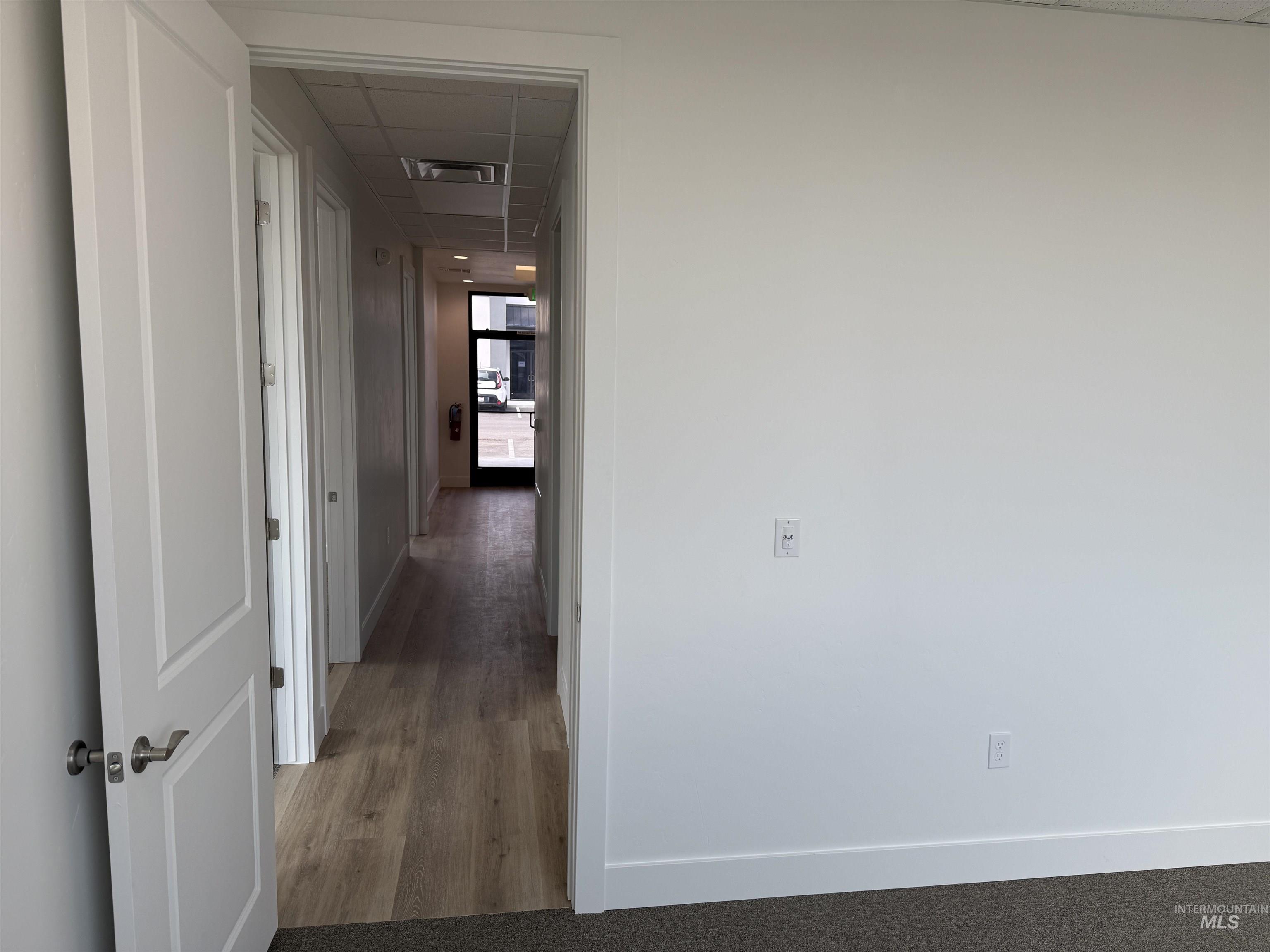 Hallway featuring a paneled ceiling and wood finished floors