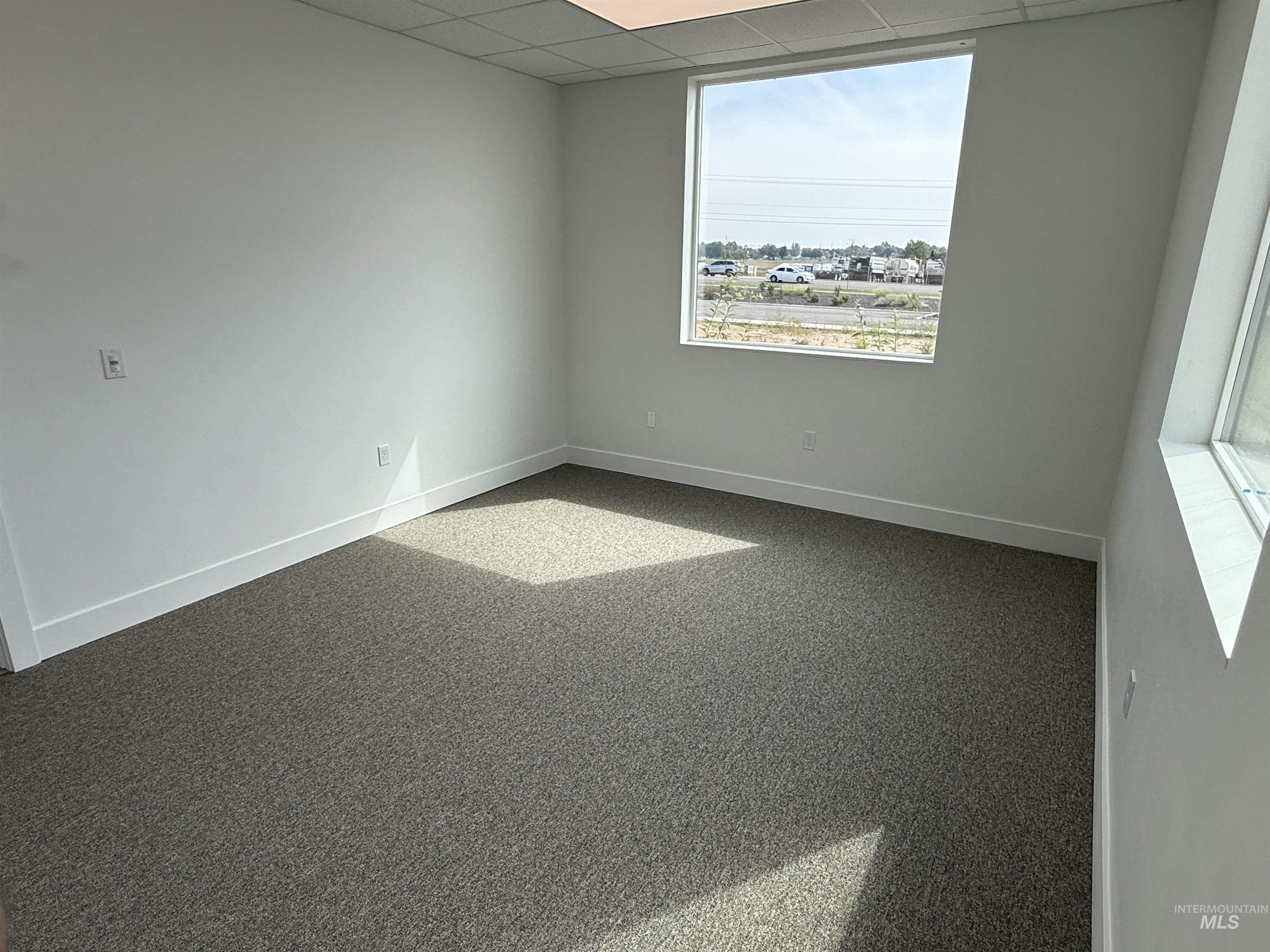 Spare room with a paneled ceiling and carpet
