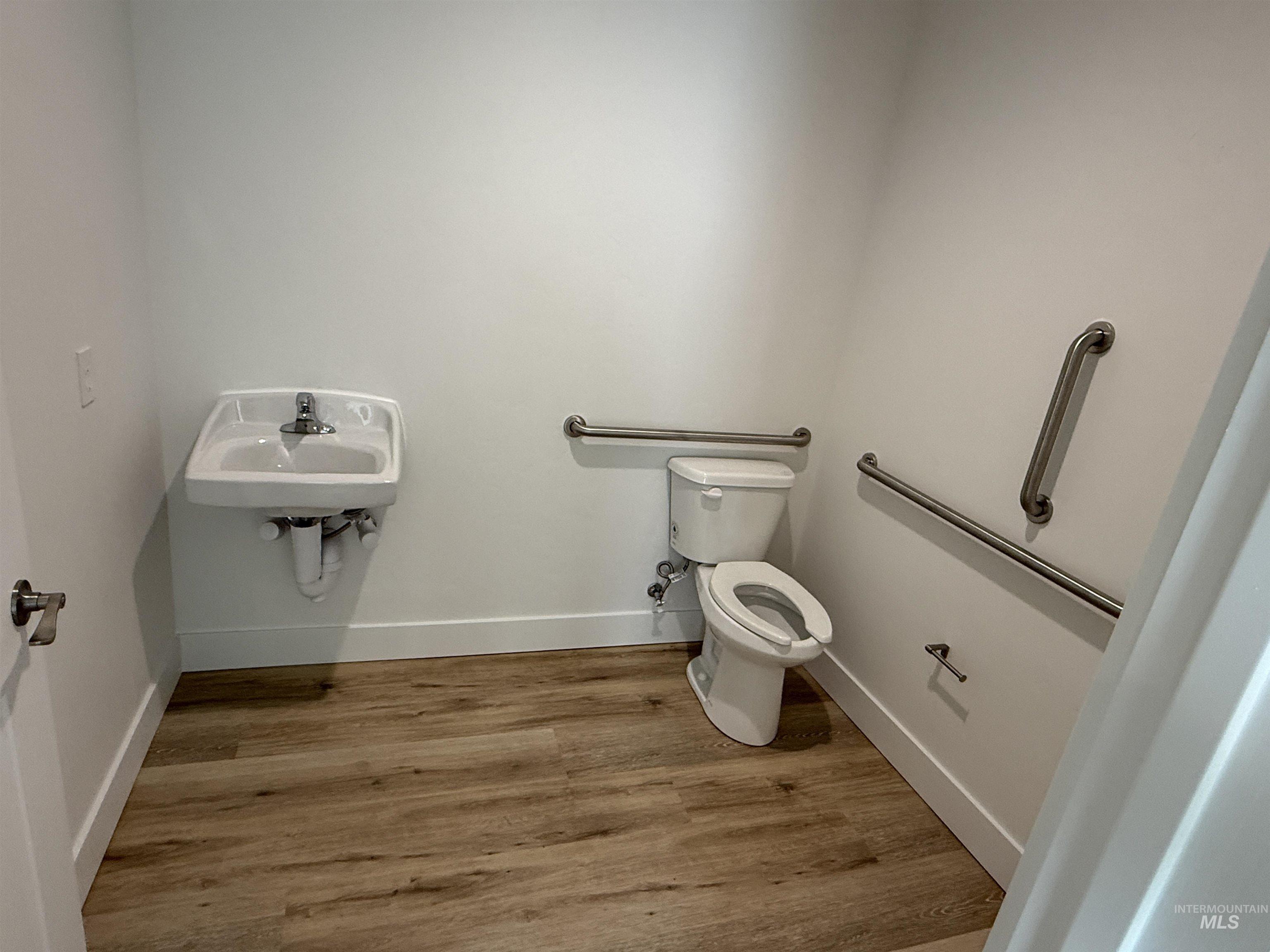 Half bathroom with toilet and light wood-style flooring