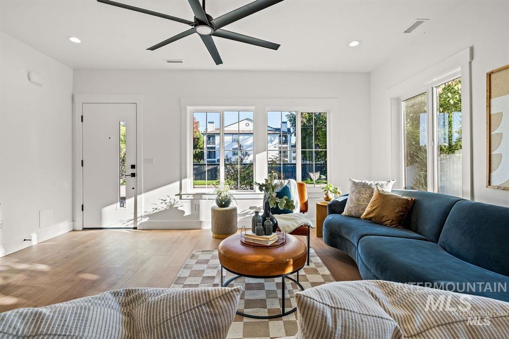 Living area with recessed lighting, wood finished floors, and a ceiling fan
