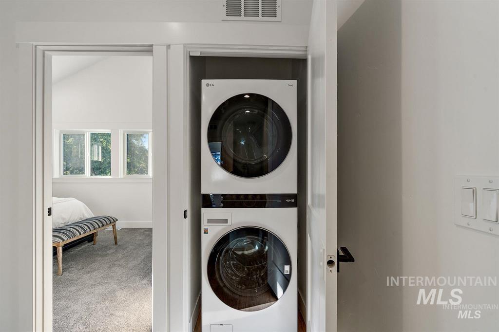 Washroom featuring carpet flooring and stacked washer / drying machine
