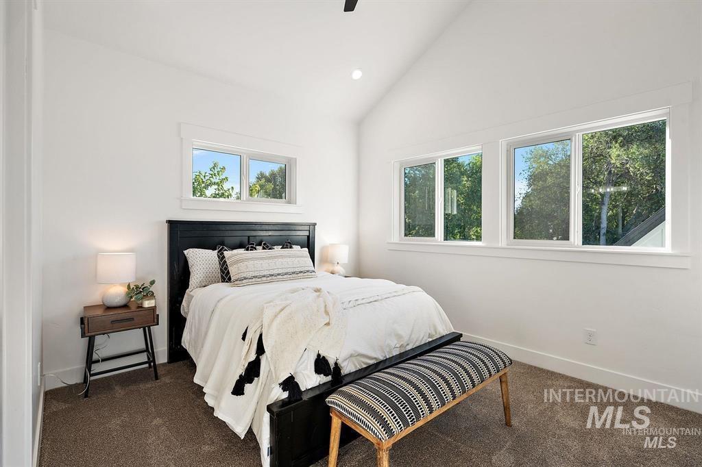 Bedroom featuring lofted ceiling, dark carpet, and recessed lighting