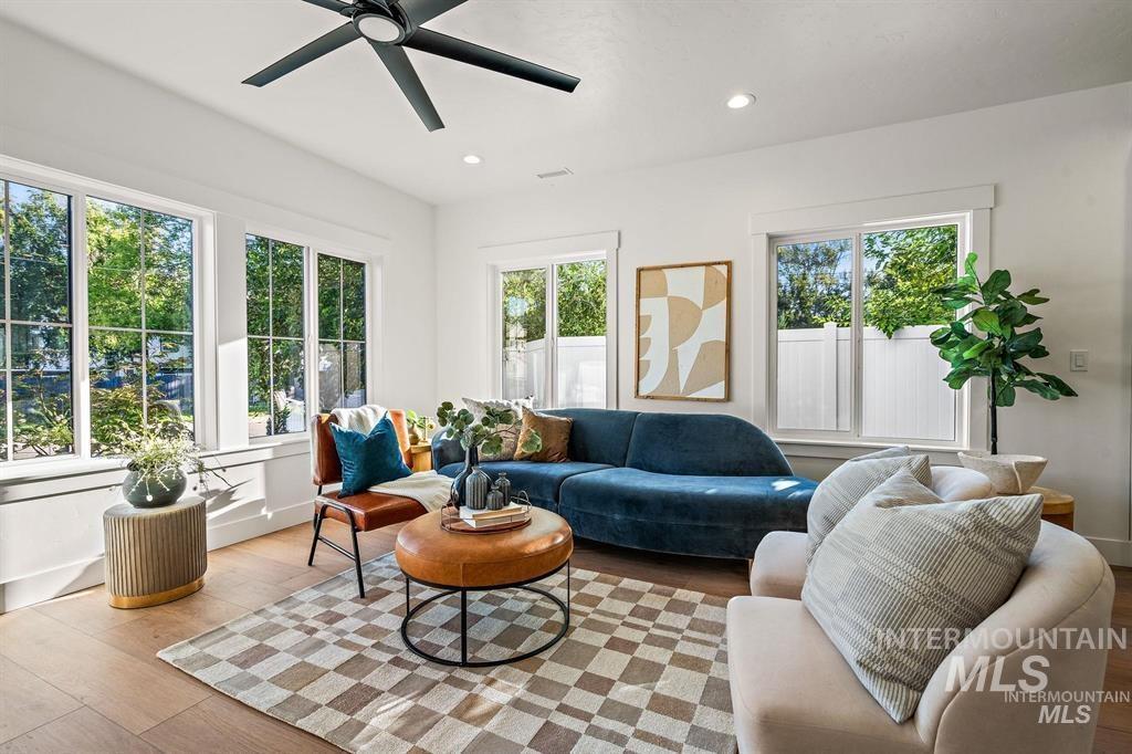 Living room with wood finished floors, recessed lighting, and a ceiling fan