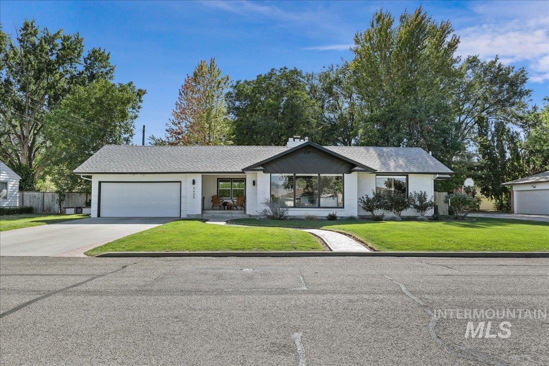 Single story home with concrete driveway, a garage, and a shingled roof