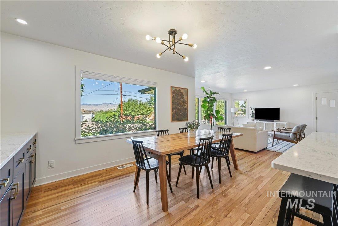 Dining space with light wood-style floors, a textured ceiling, recessed lighting, and a chandelier