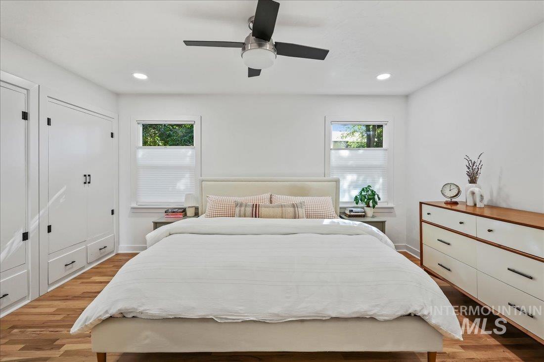 Bedroom with light wood-style floors, ceiling fan, and recessed lighting
