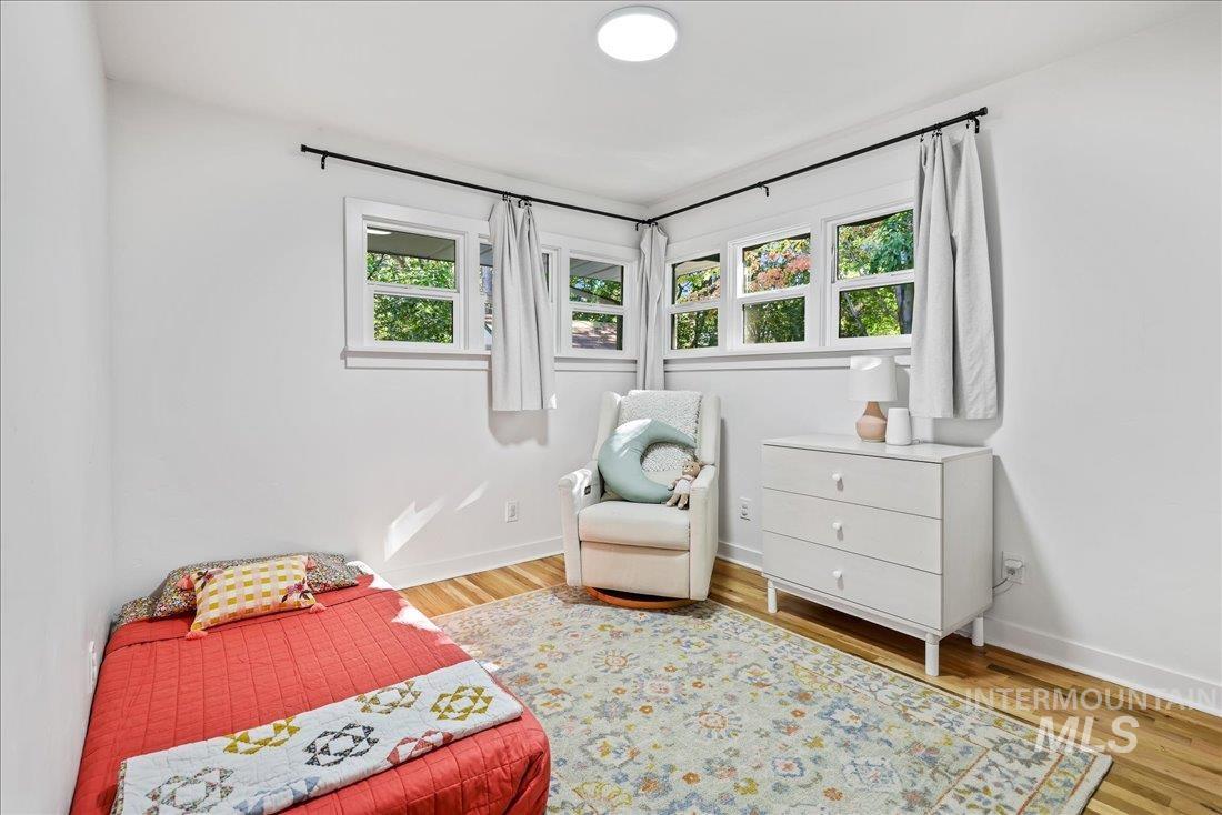 Bedroom with wood finished floors and baseboards