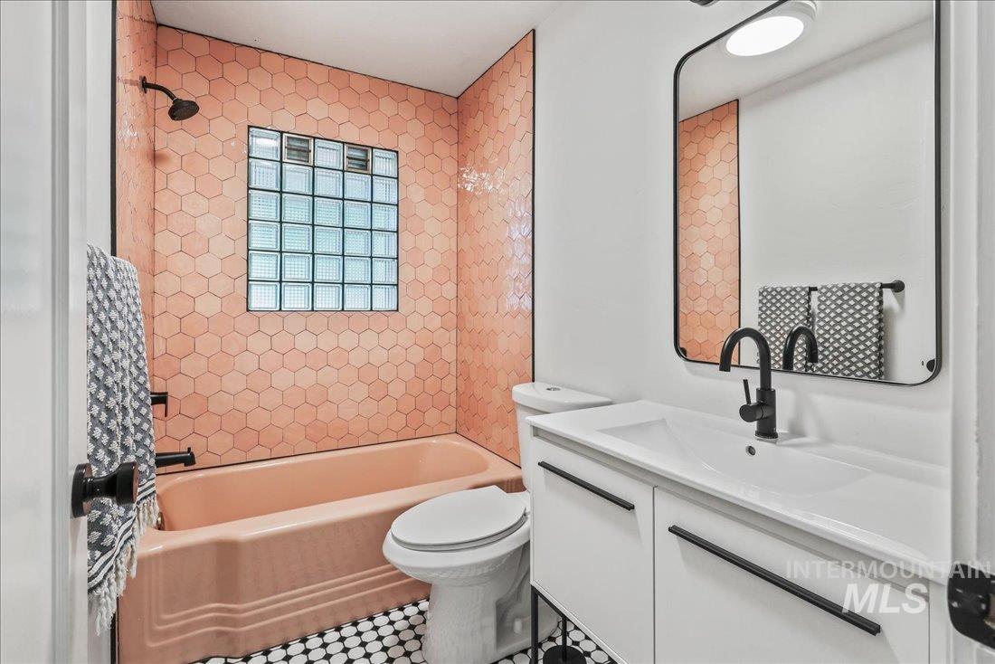 Bathroom with vanity, shower / tub combination, and tile patterned floors