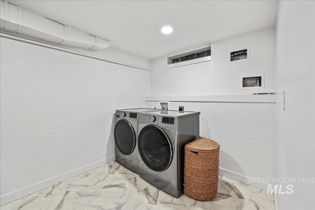 Laundry area featuring marble finish flooring and washing machine and dryer