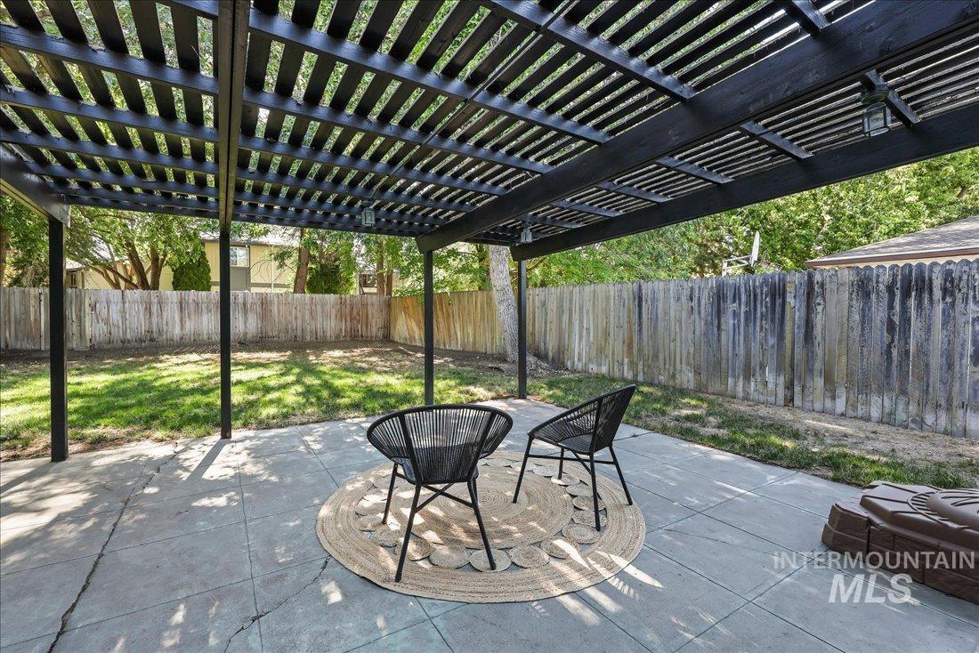 Fenced backyard with a pergola and a patio area
