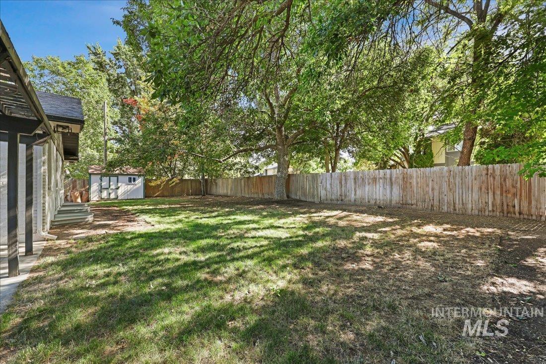 Fenced backyard with a shed and a patio