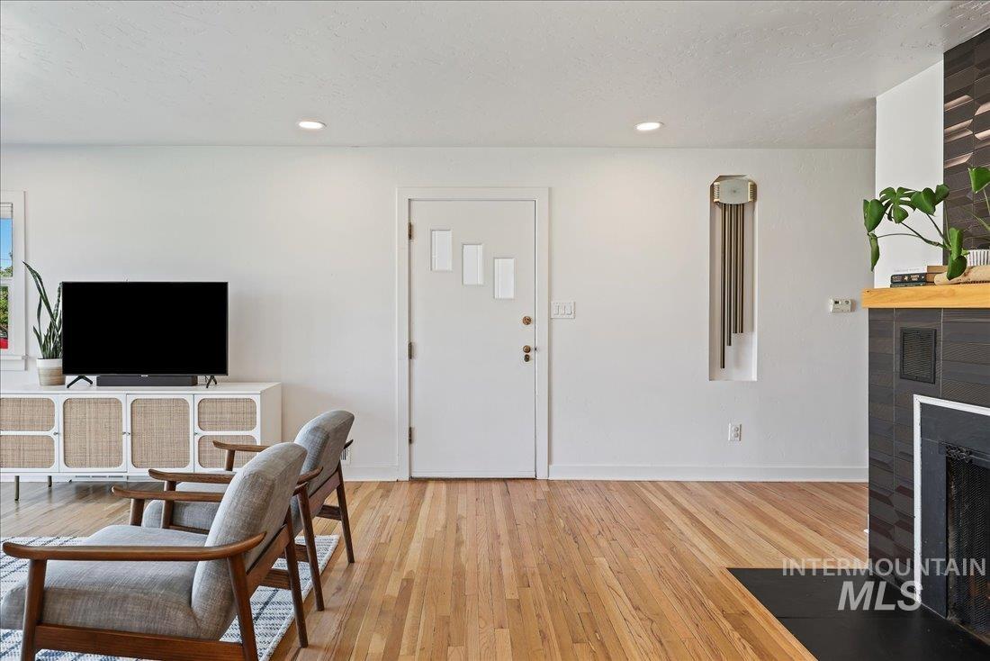 Foyer featuring a fireplace with flush hearth, wood finished floors, recessed lighting, and a textured ceiling