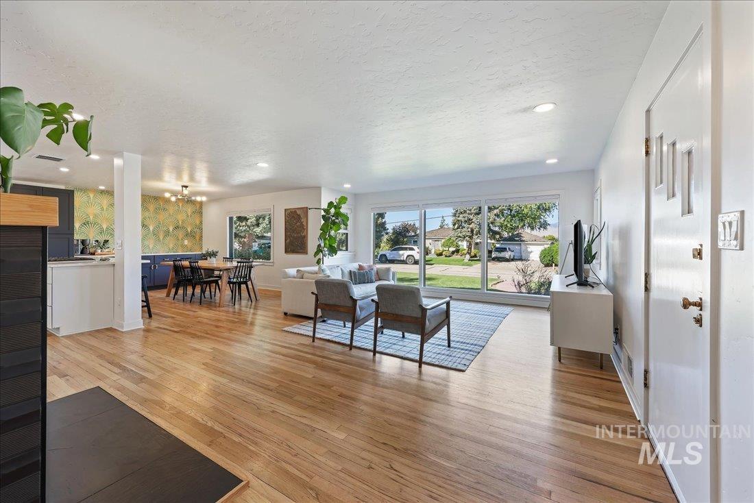 Living area with light wood-type flooring, a textured ceiling, and recessed lighting