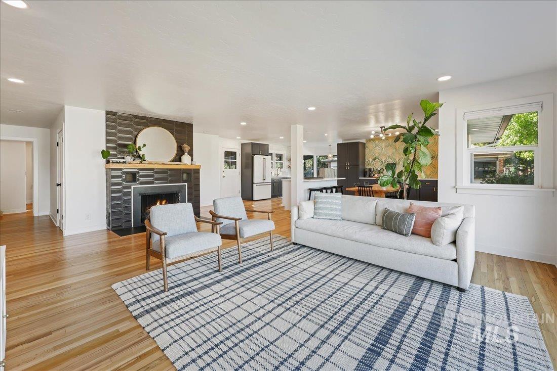 Living area with a tile fireplace, recessed lighting, and light wood-style flooring