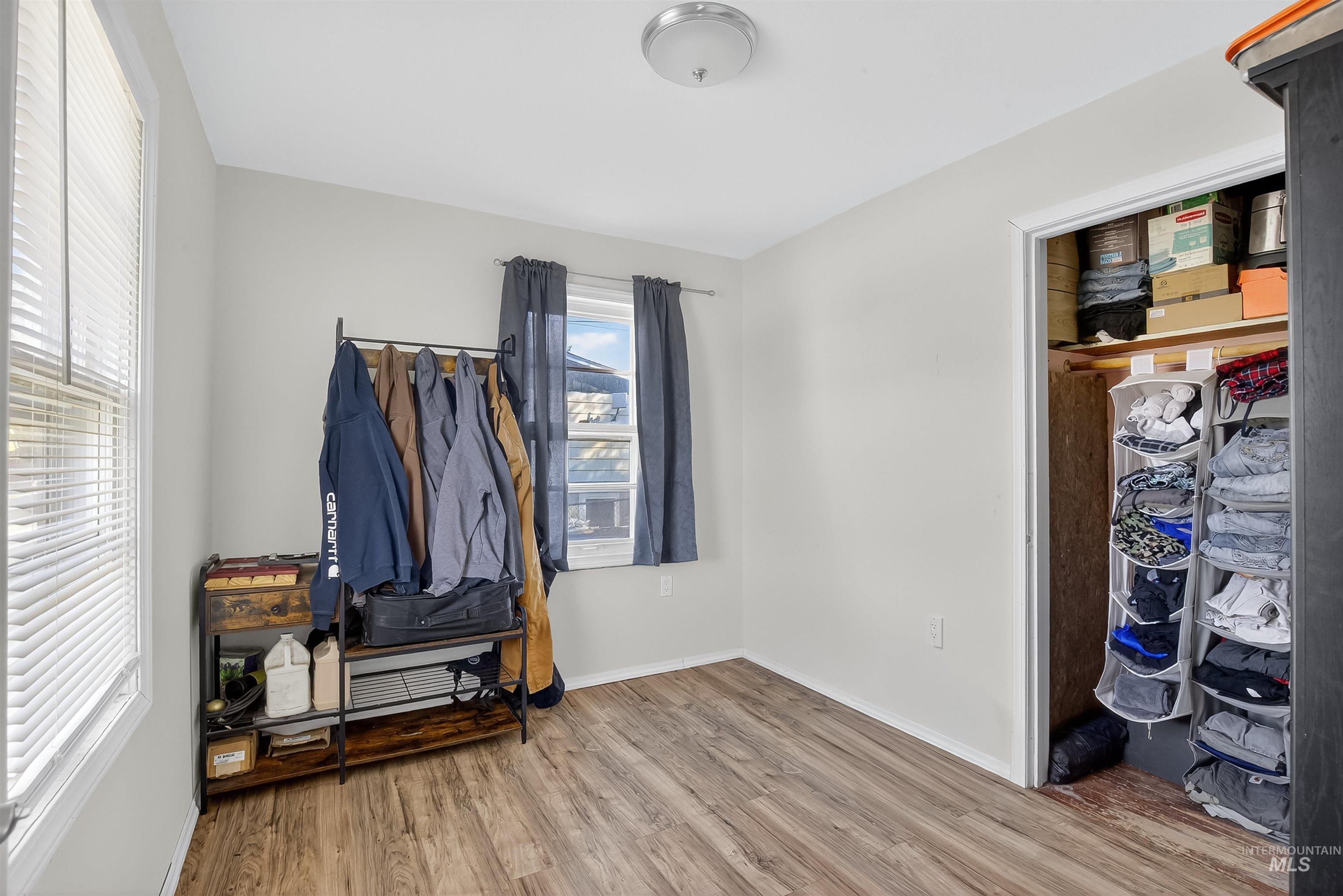 Bedroom featuring wood finished floors and baseboards
