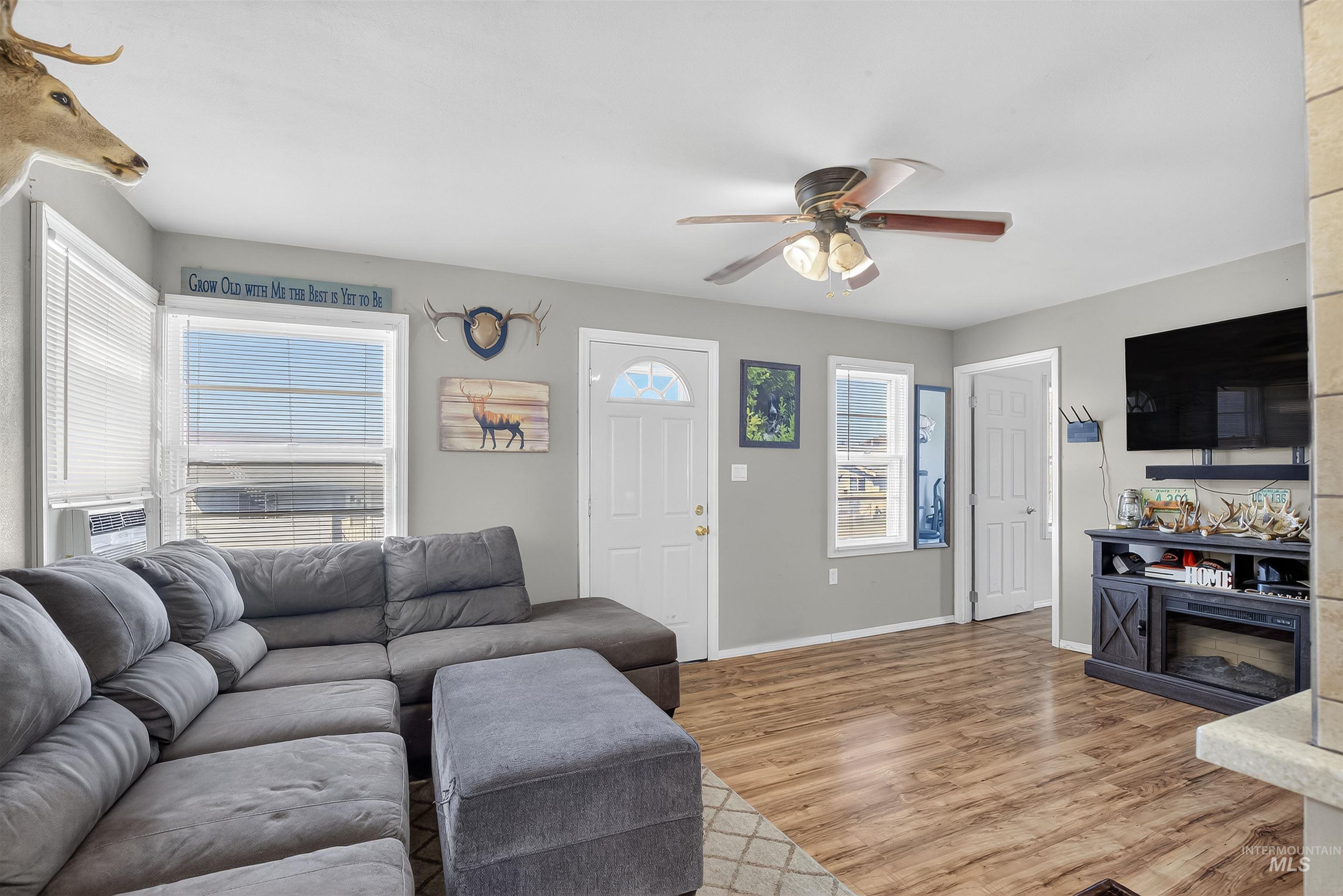 Living area featuring light wood-style floors and a ceiling fan