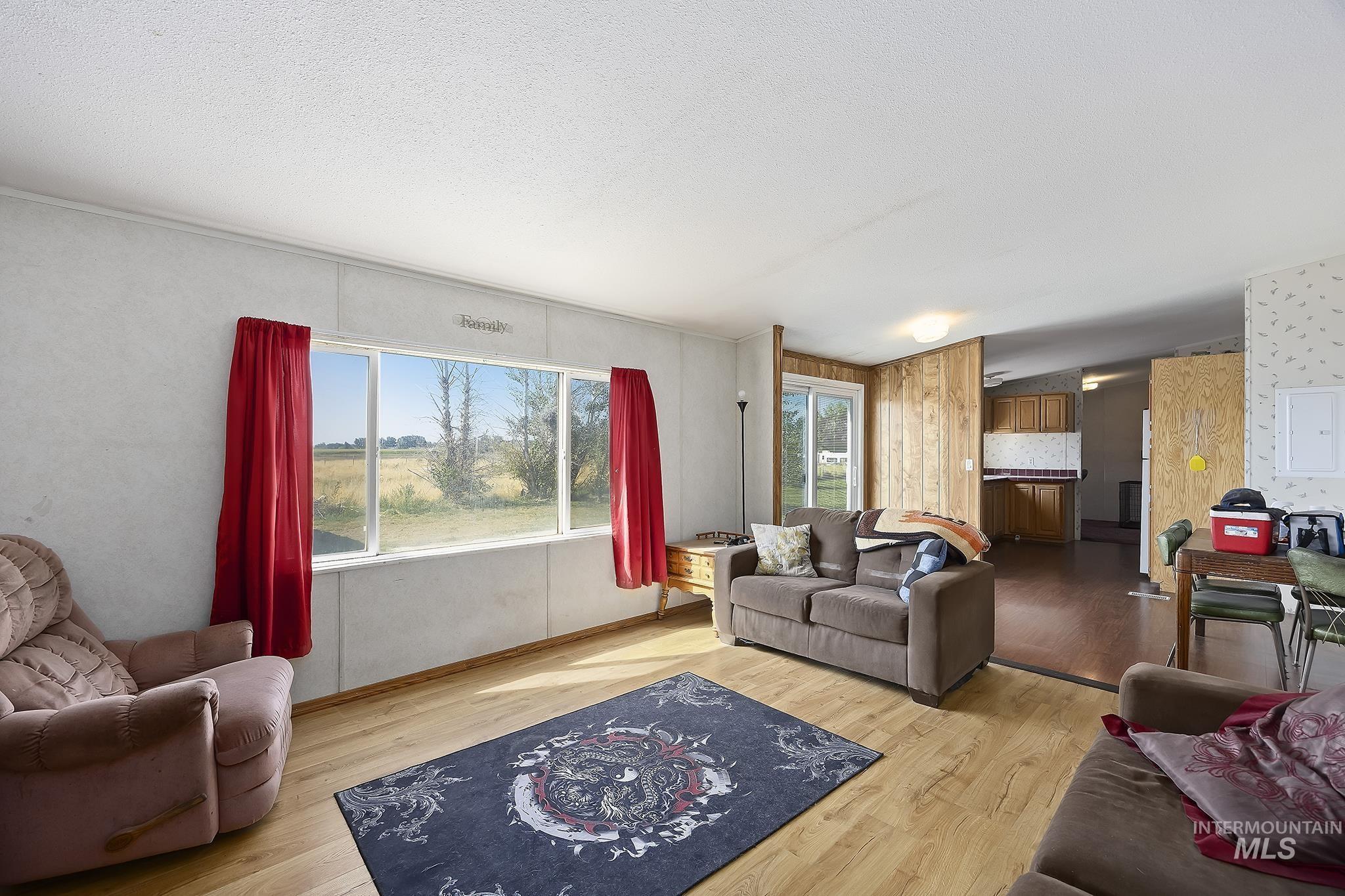 Living area with light wood-type flooring and a textured ceiling