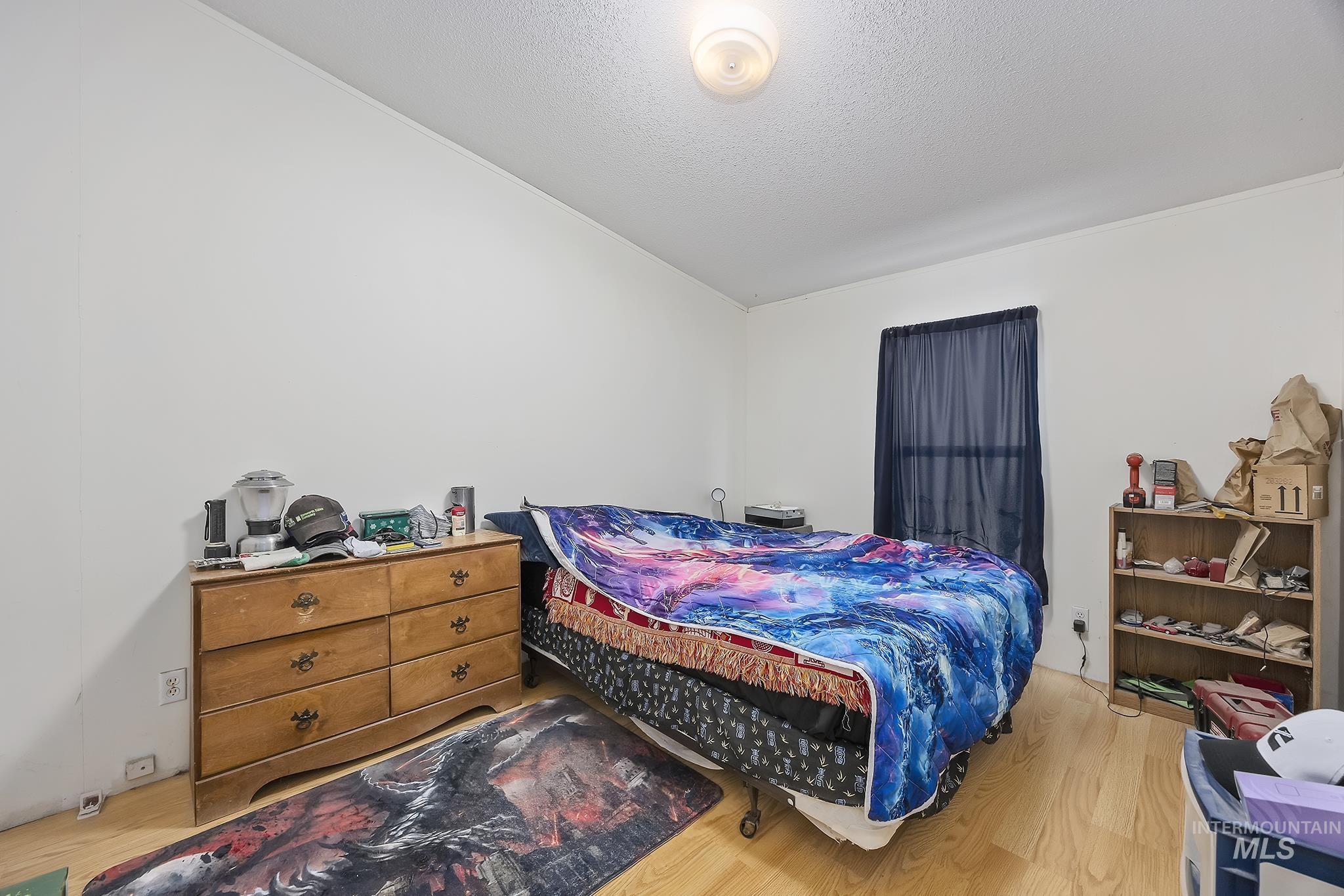 Bedroom featuring wood finished floors and a textured ceiling