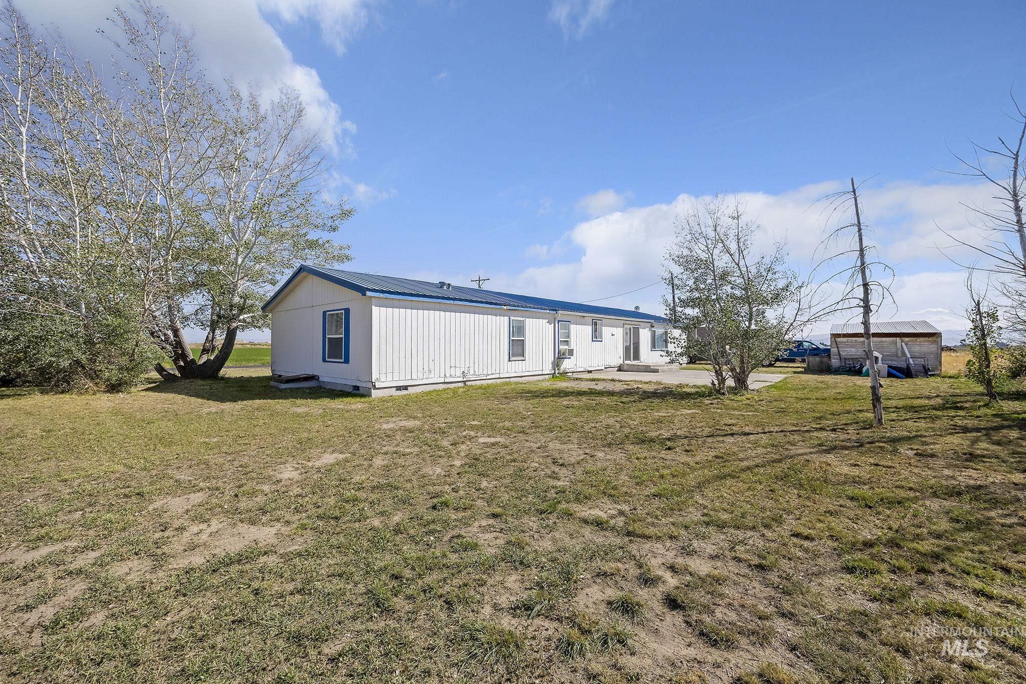 Rear view of house featuring a yard, a metal roof, and a patio