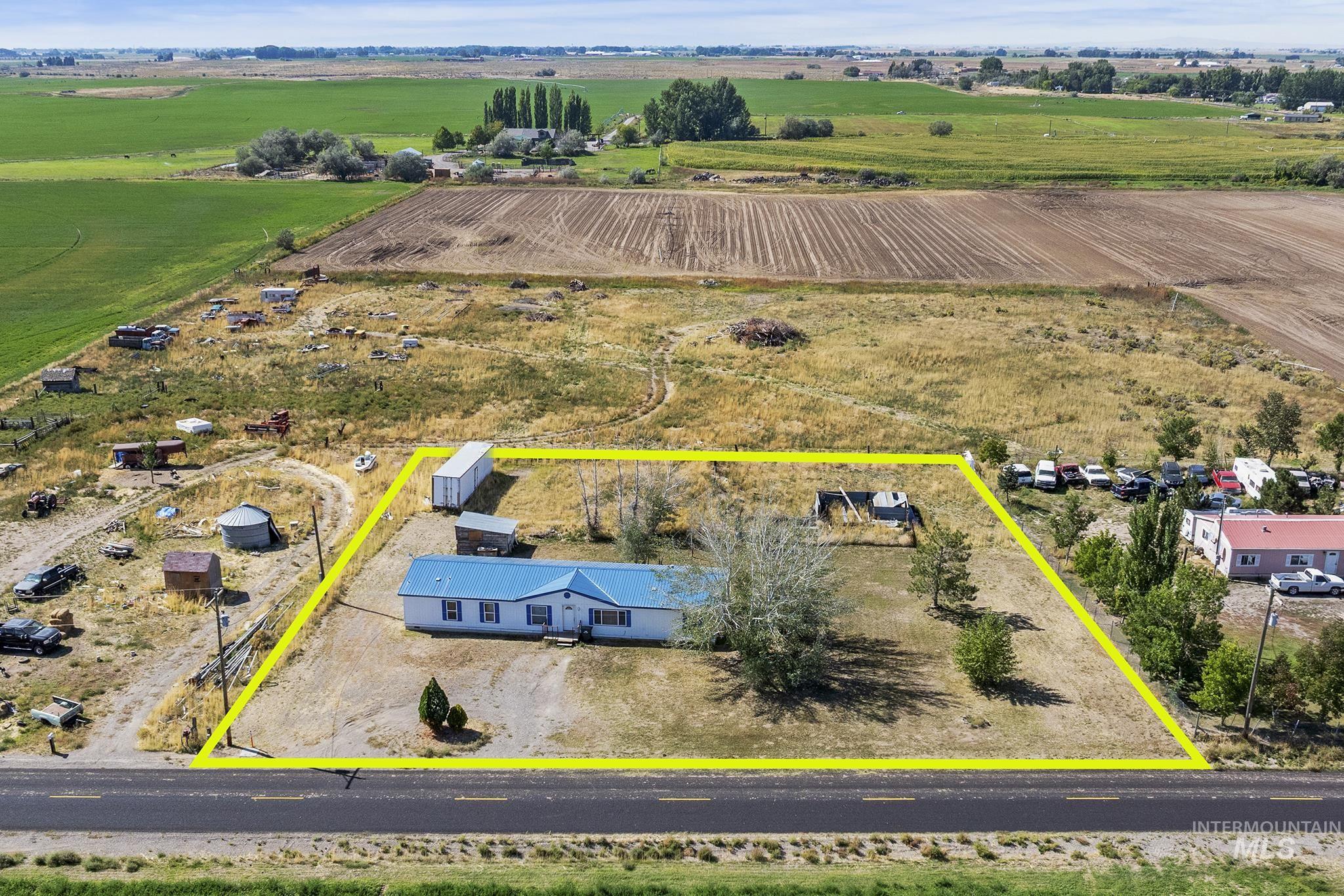 Aerial view of sparsely populated area featuring property parcel outlined and extensive farmland