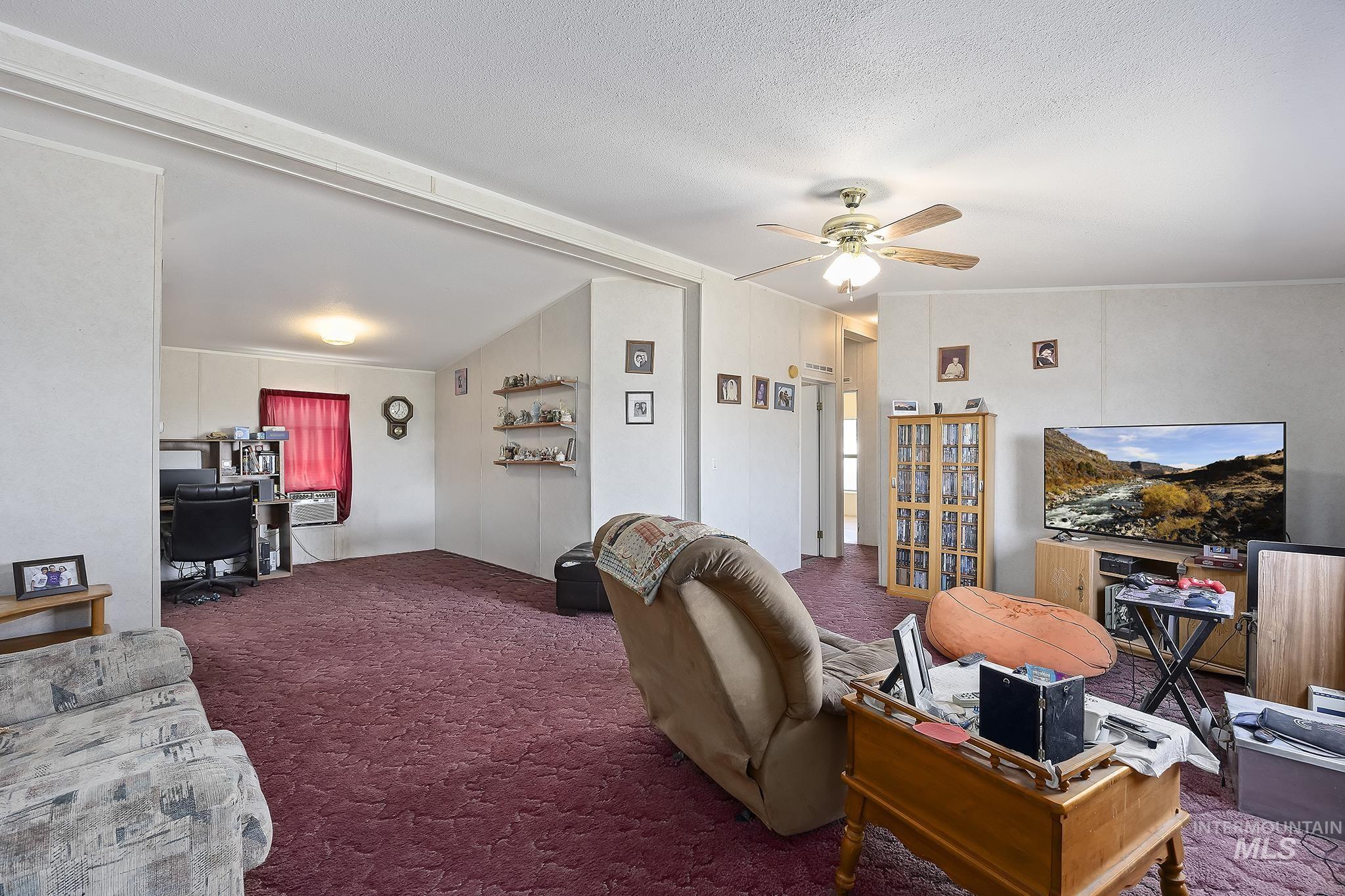 Living area featuring an office area, carpet floors, and a ceiling fan