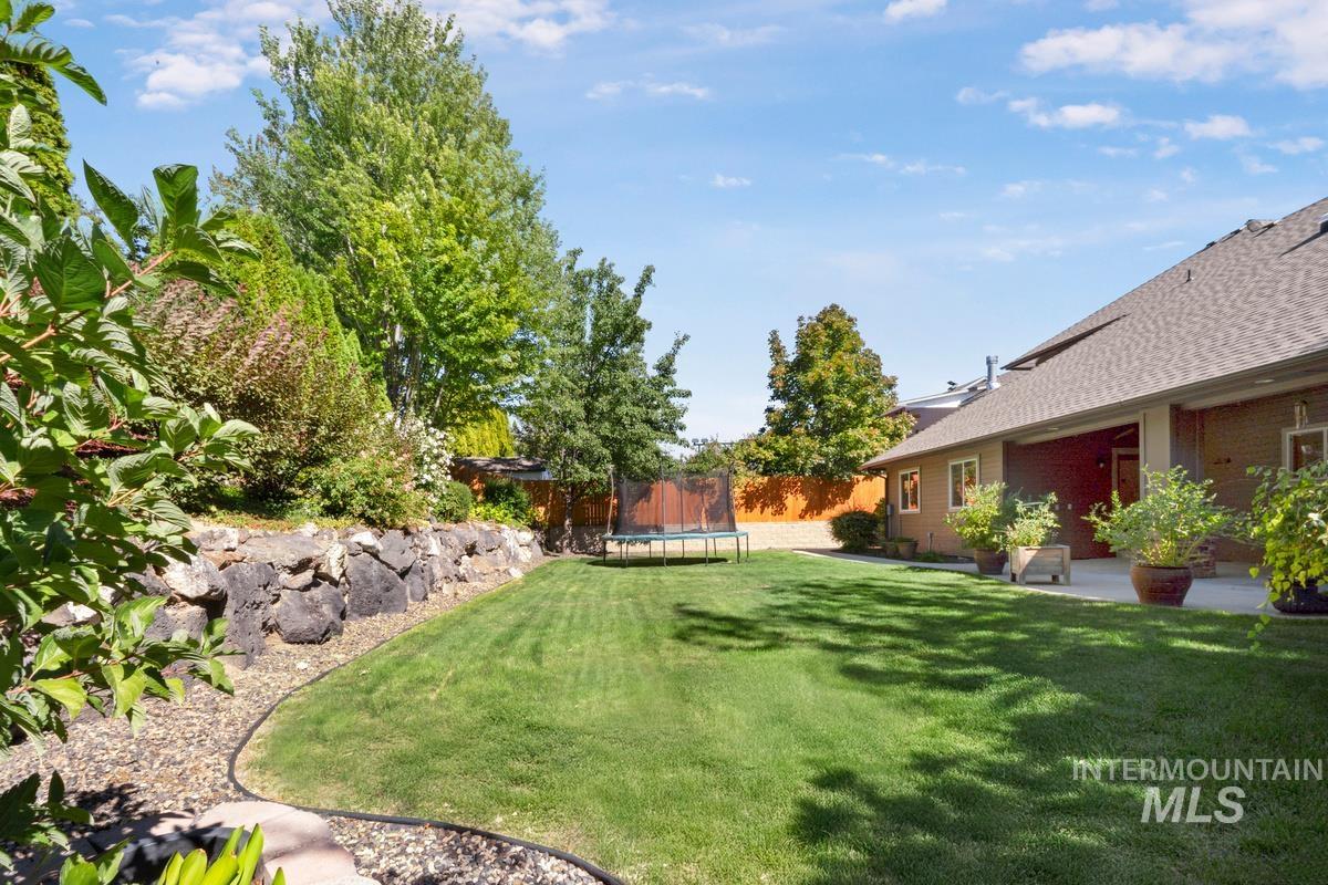 View of yard featuring a patio and a trampoline