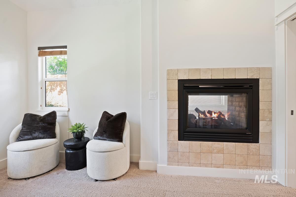 Living area with carpet and a multi sided fireplace