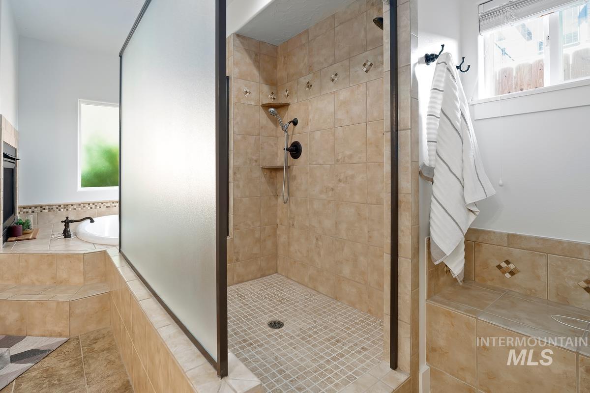 Bathroom featuring a garden tub, a stall shower, and tile patterned floors