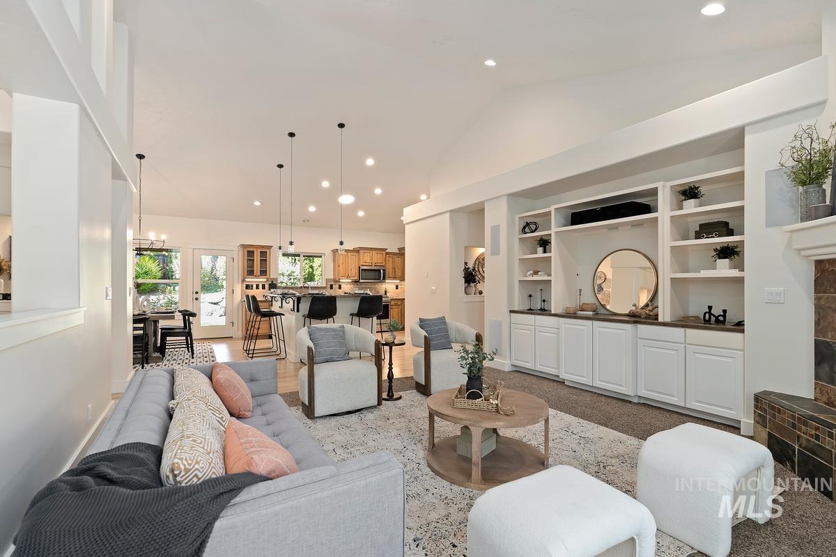 Living area featuring recessed lighting, vaulted ceiling, a chandelier, and built in shelves