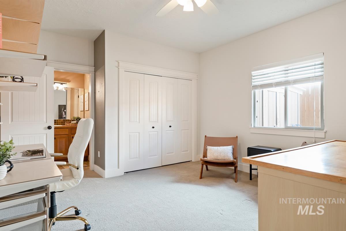 Office space with light colored carpet and ceiling fan