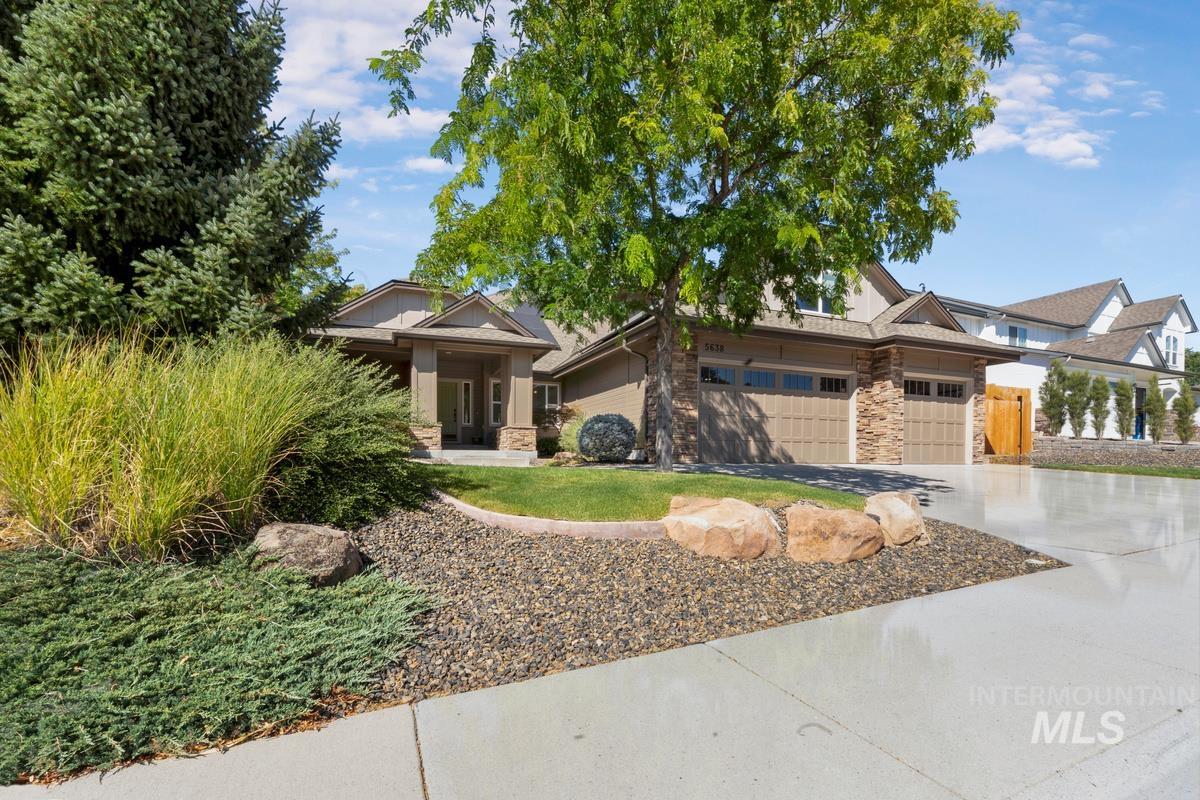 View of front of property with stone siding, concrete driveway, and an attached garage