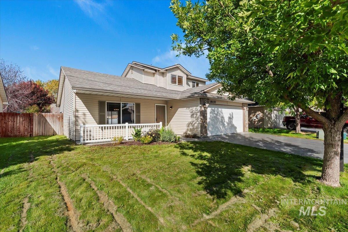 View of front of property featuring driveway, a porch, a shingled roof, and an attached garage