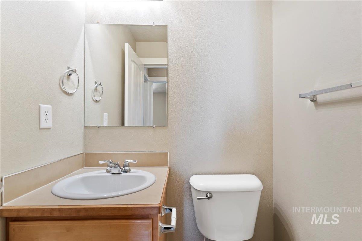 Half bath with a textured wall and vanity