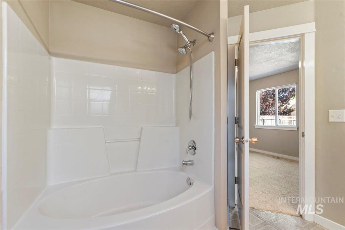 Bathroom featuring  shower combination and a textured ceiling
