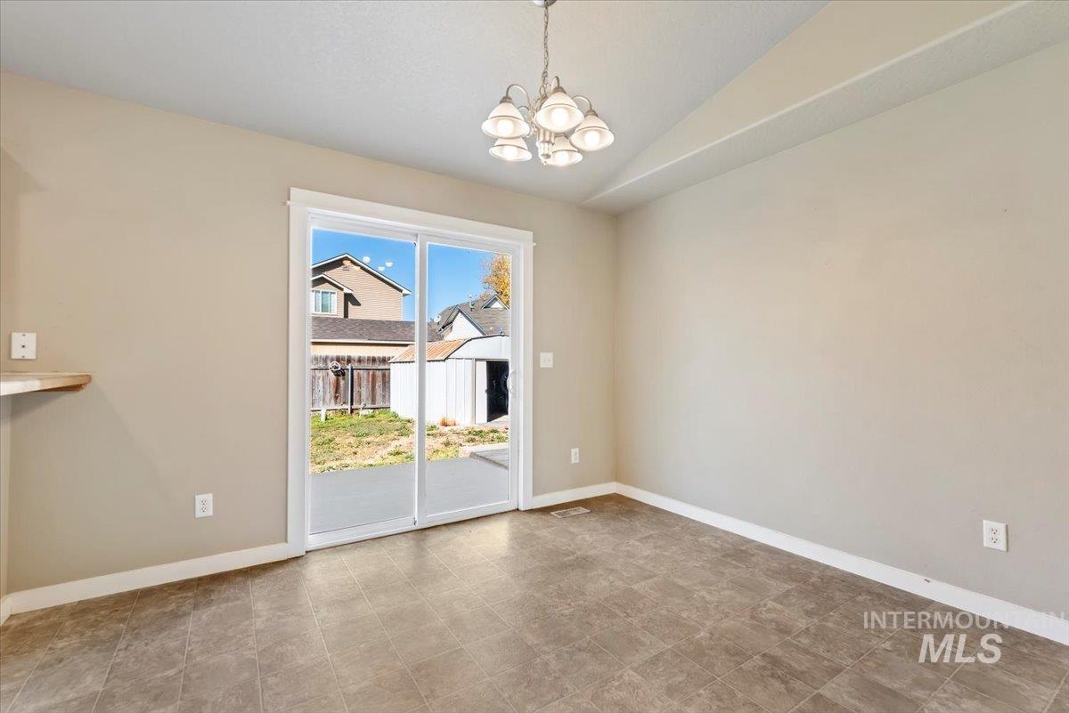 Unfurnished dining area featuring a chandelier and vaulted ceiling