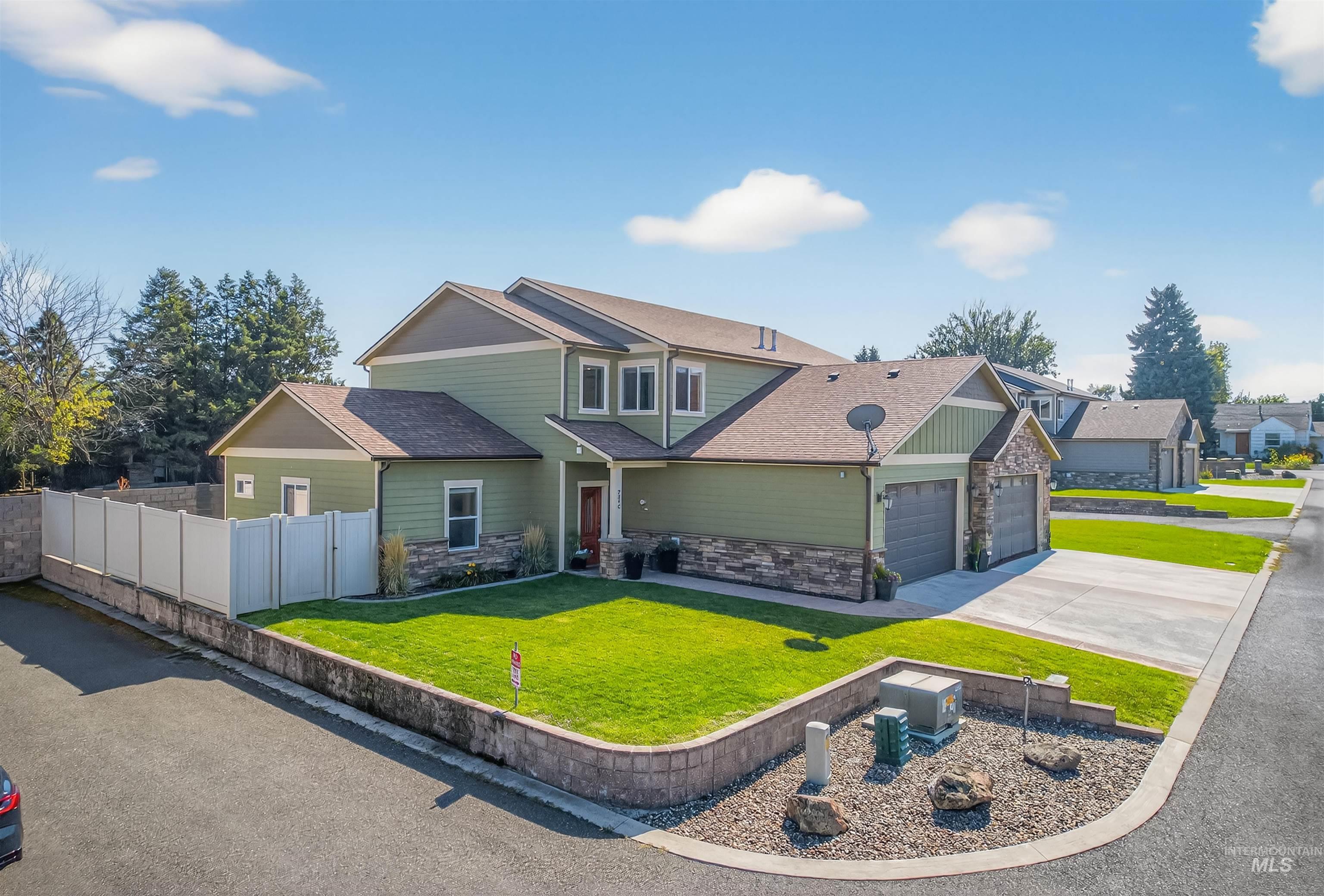 Craftsman inspired home featuring stone siding, a shingled roof, driveway, and a garage