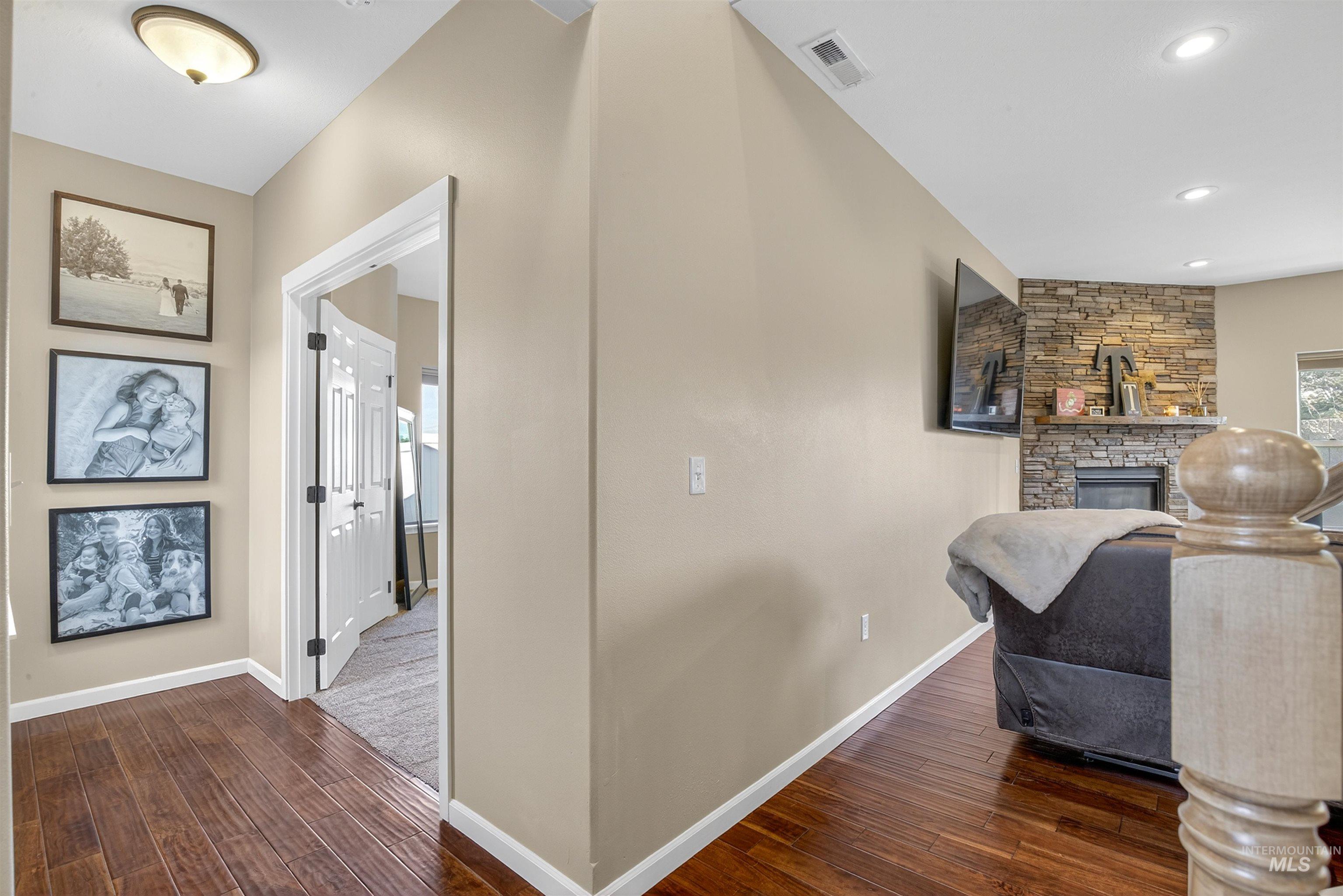 Living area with dark wood-type flooring, a fireplace, and recessed lighting