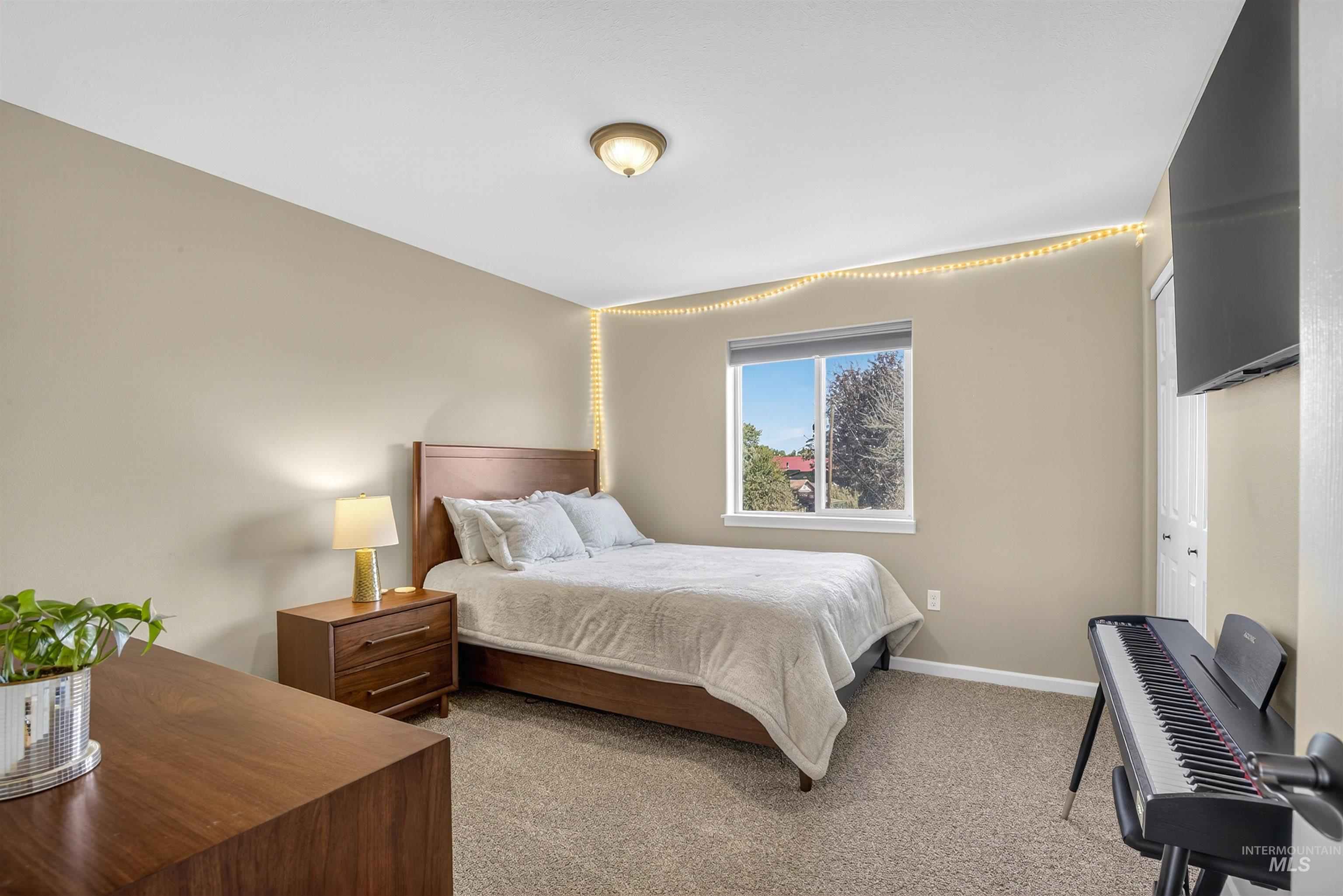 Bedroom with light colored carpet and a closet