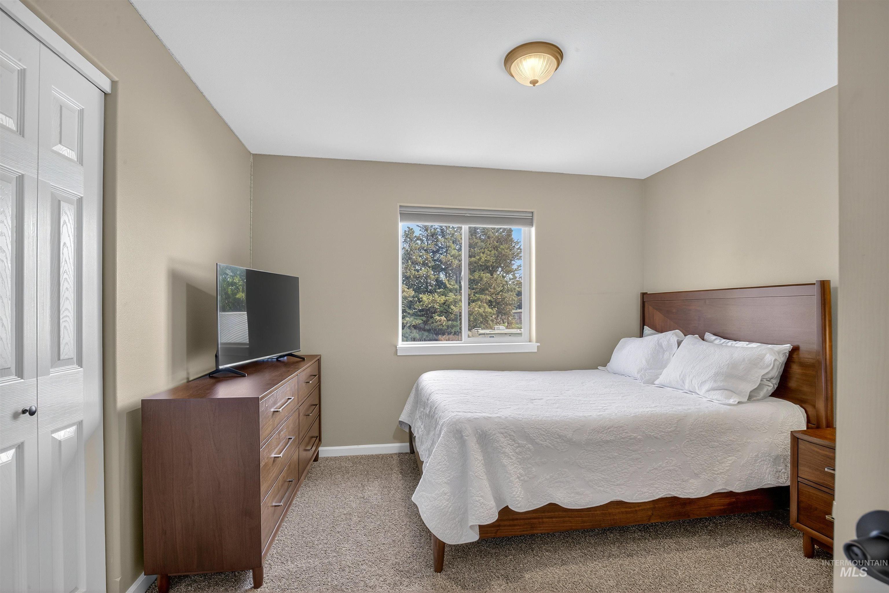 Bedroom featuring light colored carpet and baseboards