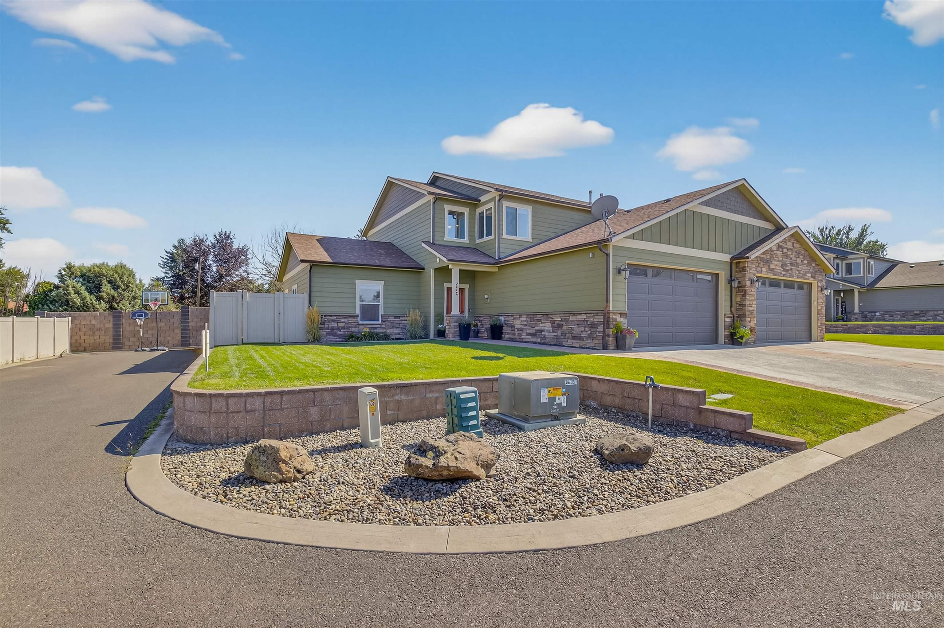 Craftsman inspired home featuring stone siding, driveway, a garage, board and batten siding, and a shingled roof
