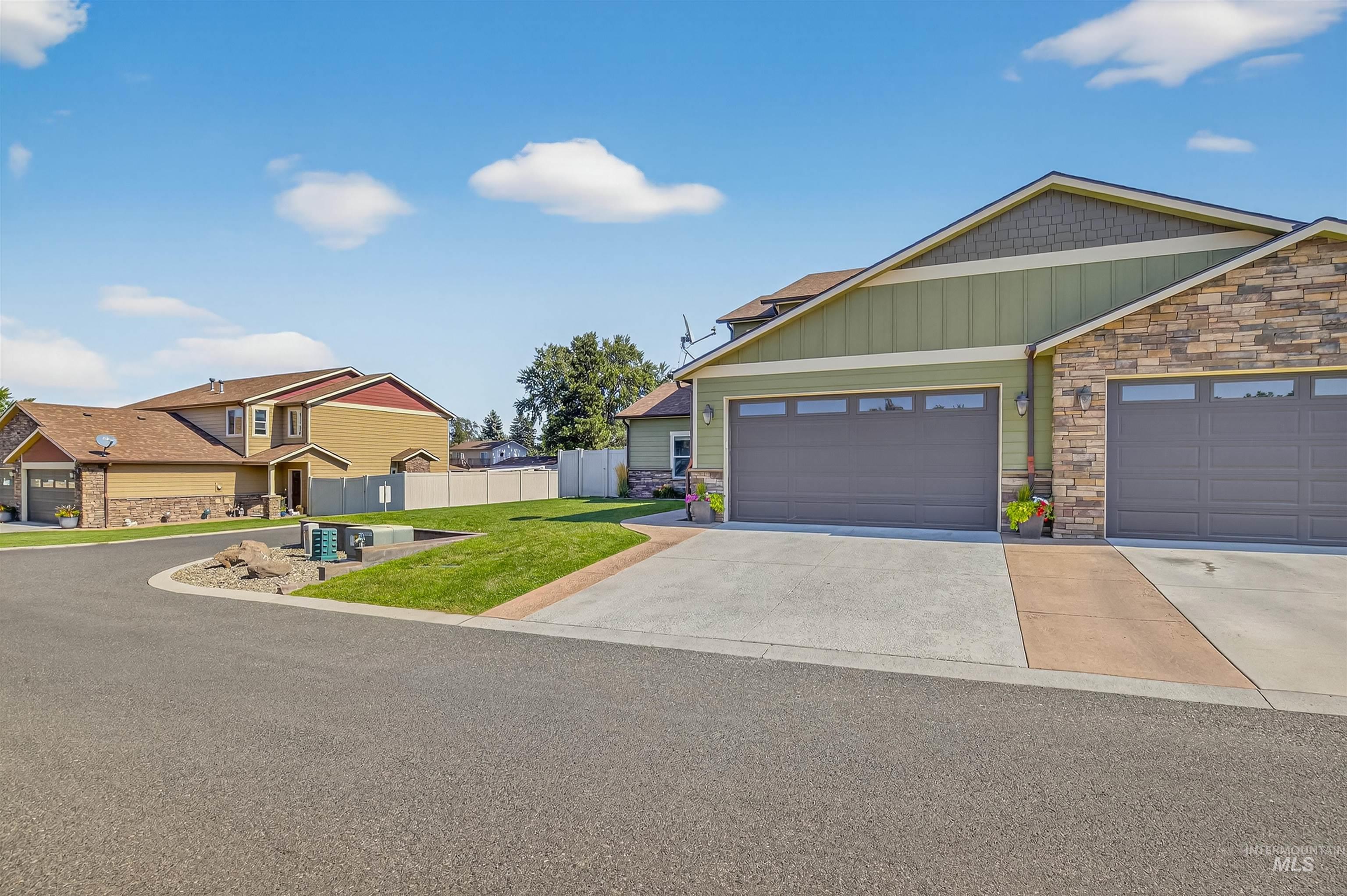 Craftsman house featuring stone siding, driveway, board and batten siding, and an attached garage