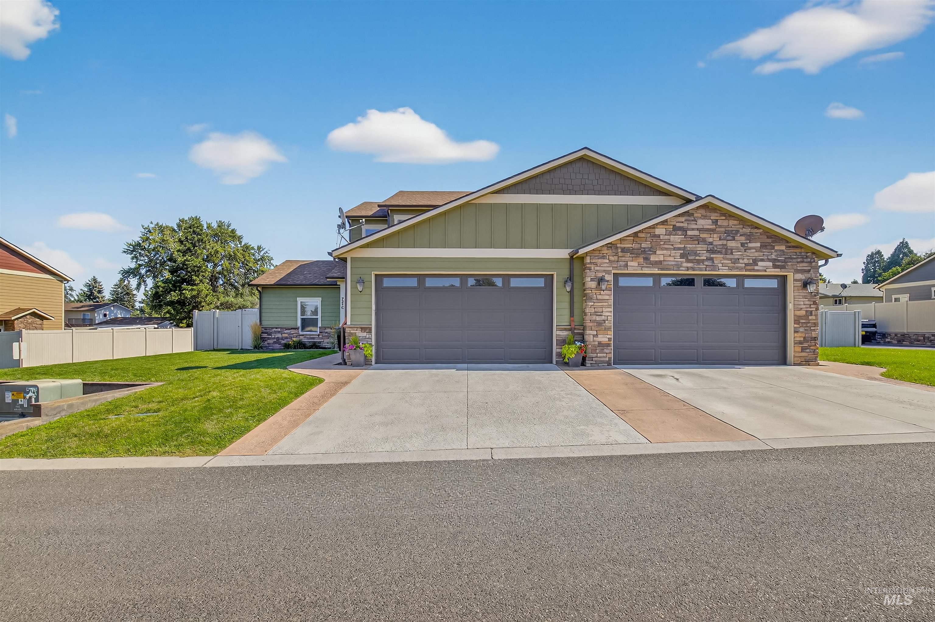 Craftsman-style house with concrete driveway, stone siding, an attached garage, and board and batten siding
