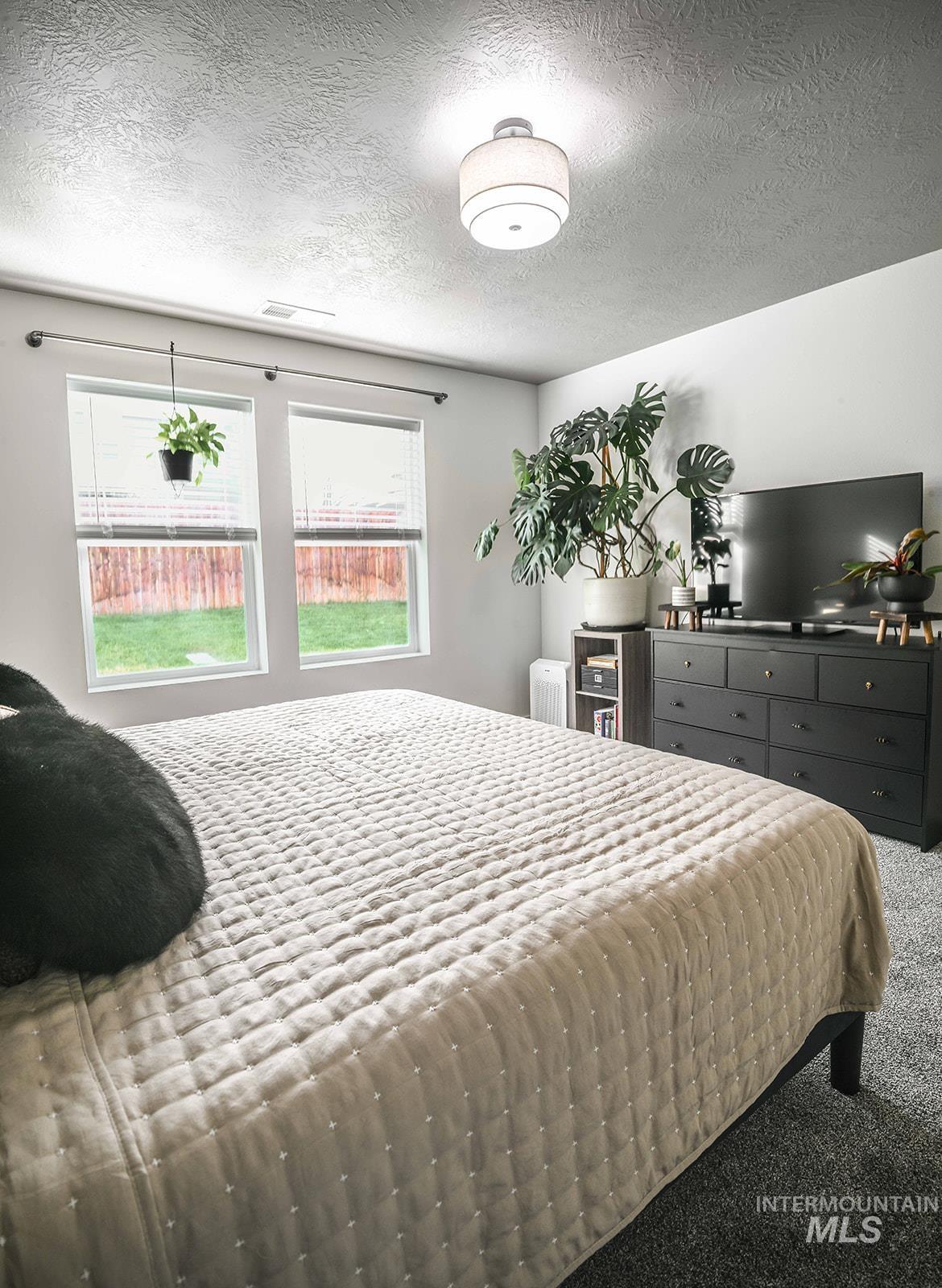 Carpeted bedroom with a textured ceiling