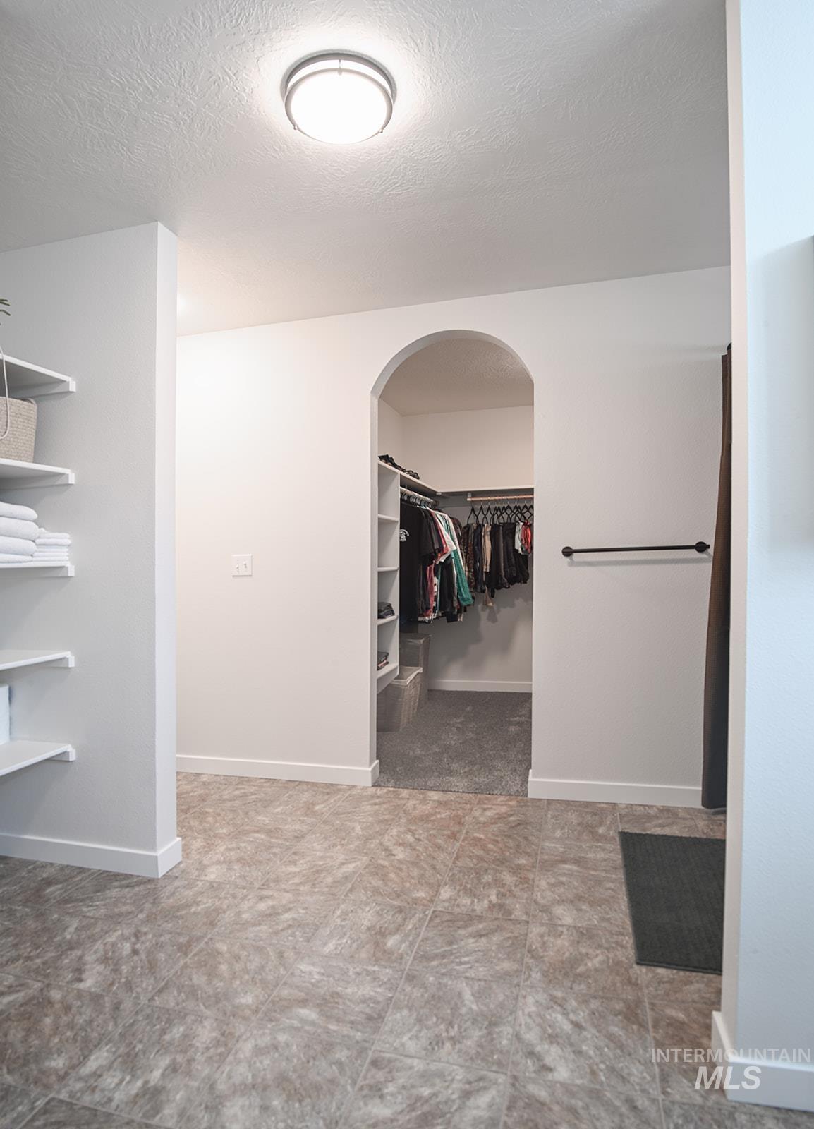 Spacious closet featuring arched walkways